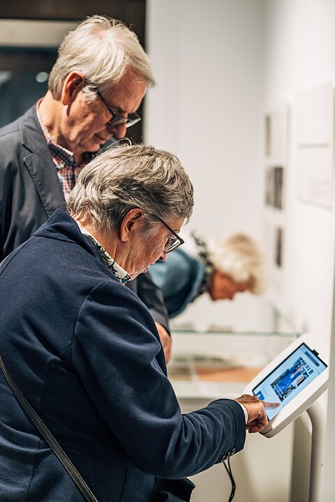 Ausstellungsbesuchende an der Medienstation