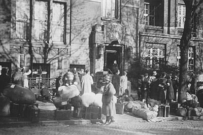 Schwarzweißfoto von Menschen, die unter Bewachung des Reserve-Polizeibataillons 101 am Logengebäude ankommen
