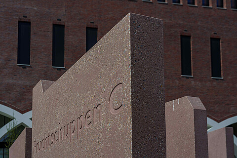 Detailblick eine Stele mit der Aufschrift Fruchtschuppen C vor dem Westfield Hamburg-Überseequartier