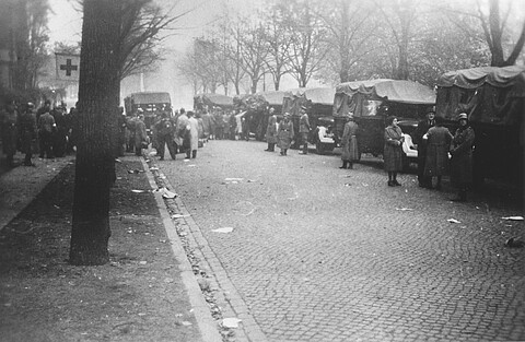 Schwarzweißfoto von Menschen, die an einer Kopfsteinpflasterstraße in Polizei-Lkws für den Abtransport zum Hannoverschen Bahnhof steigen